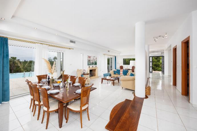 Open-plan living room on first floor with sofas, dining area, kitchen, ornamental fireplace, A/C, and WiFi internet . - Villa Noulia . (Photo Gallery) }}