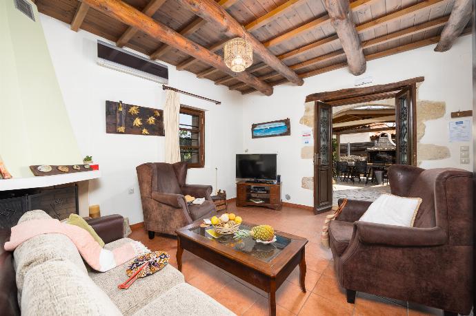 Living room with sofa, ornamental fireplace, A/C, WiFi internet, and satellite TV . - Villa Kourkoulios . (Photo Gallery) }}