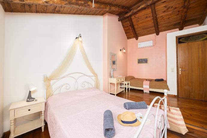 Bedroom with double bed, single bed, and A/C . - Villa Kourkoulios . (Photo Gallery) }}