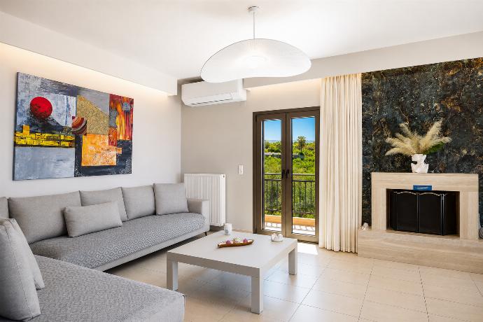 Open-plan living room with sofas, dining area, kitchen, ornamental fireplace, A/C, WiFi internet, and satellite TV . - Villa Kyveli . (Photo Gallery) }}
