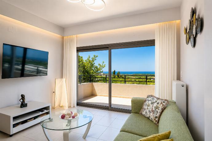 Open-plan living room with sofas, dining area, kitchen, ornamental fireplace, A/C, WiFi internet, and satellite TV . - Villa Kyveli . (Photo Gallery) }}