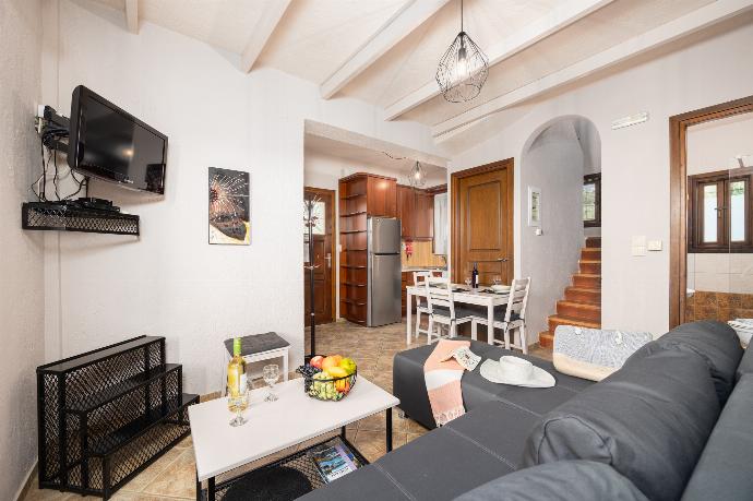 Unit 1: open-plan living room with sofa, dining area, kitchen, A/C, WiFi internet, and satellite TV . - Panorama II Villas . (Photo Gallery) }}