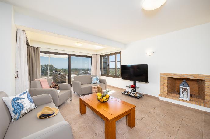 Open-plan living room with sofa, dining area, kitchen, ornamental fireplace, A/C, WiFi internet, and satellite TV . - Villa Elena . (Galleria fotografica) }}