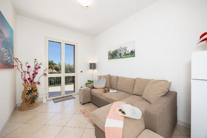 Open-plan living room with sofa, dining area, kitchen, A/C, WiFi internet, and satellite TV . - Villetta Bianca . (Photo Gallery) }}