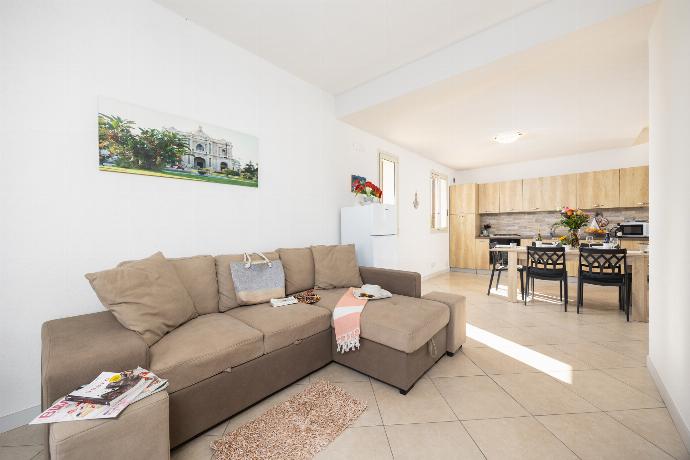 Open-plan living room with sofa, dining area, kitchen, A/C, WiFi internet, and satellite TV . - Villetta Bianca . (Photo Gallery) }}