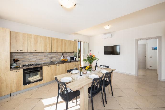 Open-plan living room with sofa, dining area, kitchen, A/C, WiFi internet, and satellite TV . - Villetta Bianca . (Photo Gallery) }}