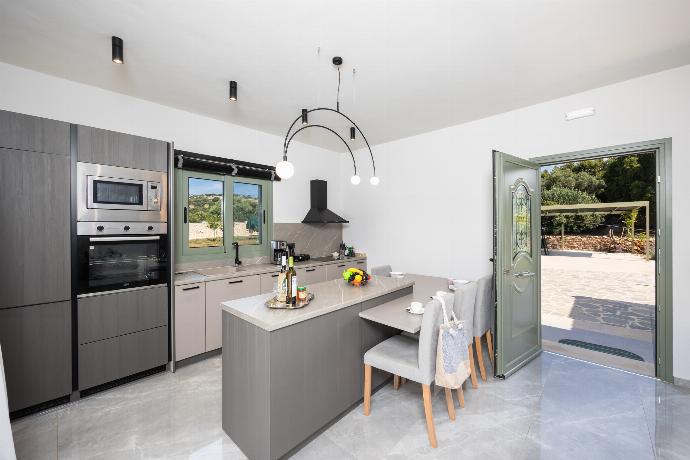 Open-plan living room with sofa, kitchen, A/C, WiFi internet, and satellite TV . - Villa Tania Ena . (Photo Gallery) }}