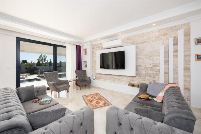 Main building: open-plan living room with sofas, dining area, kitchen, A/C, WiFi internet, and satellite TV . - Villa Tolga . (Photo Gallery) }}