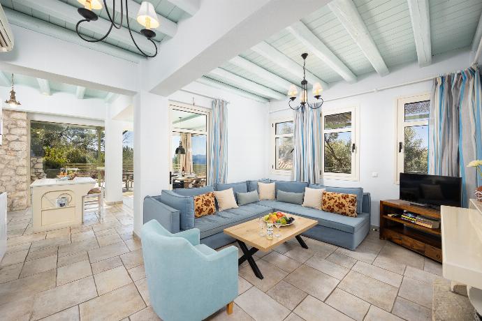 Open-plan living room with sofa, dining area, kitchen, ornamental fireplace, A/C, WiFi internet, and satellite TV . - Villa Anemus . (Photo Gallery) }}