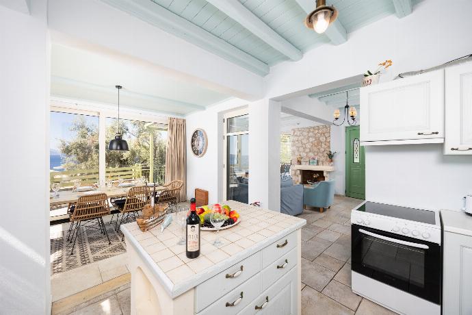 Open-plan living room with sofa, dining area, kitchen, ornamental fireplace, A/C, WiFi internet, and satellite TV . - Villa Anemus . (Photo Gallery) }}