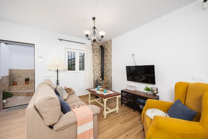 Open-plan living room with sofa, dining area, kitchen, ornamental fireplace, WiFi internet, and satellite TV . - Villa El Cortijo . (Photo Gallery) }}