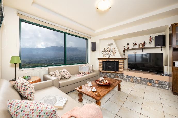 Open-plan living room with sofas, dining areas, kitchen, ornamental fireplace, A/C, WiFi internet, and satellite TV . - Aloni Villa . (Photo Gallery) }}