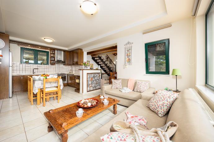 Open-plan living room with sofas, dining areas, kitchen, ornamental fireplace, A/C, WiFi internet, and satellite TV . - Aloni Villa . (Photo Gallery) }}