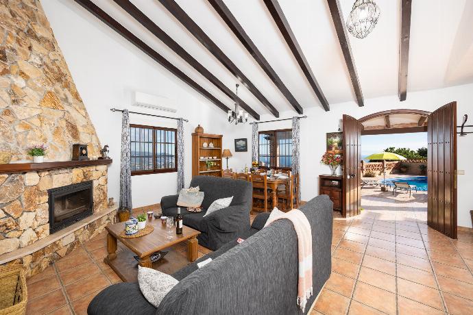 Open-plan living room with sofas, dining area, kitchen, ornamental fireplace, A/C, WiFi internet, and satellite TV . - Villa Baena . (Photo Gallery) }}