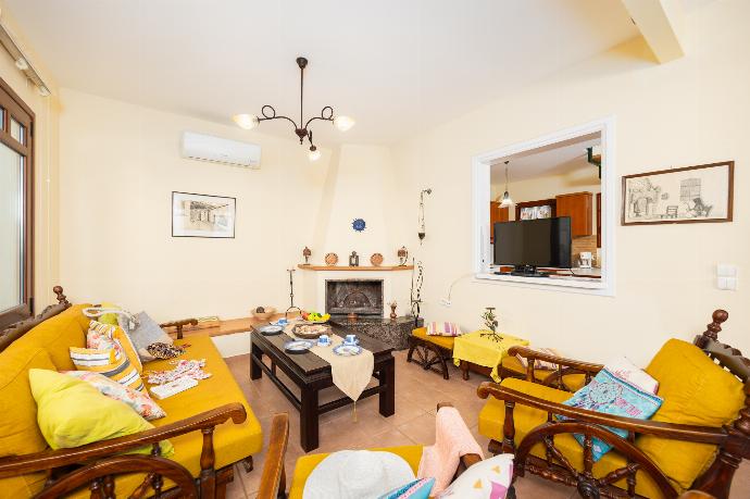 Living room with sofa, dining area, ornamental fireplace, A/C, WiFi internet, and sea views . - Villa Aphrodite . (Photo Gallery) }}