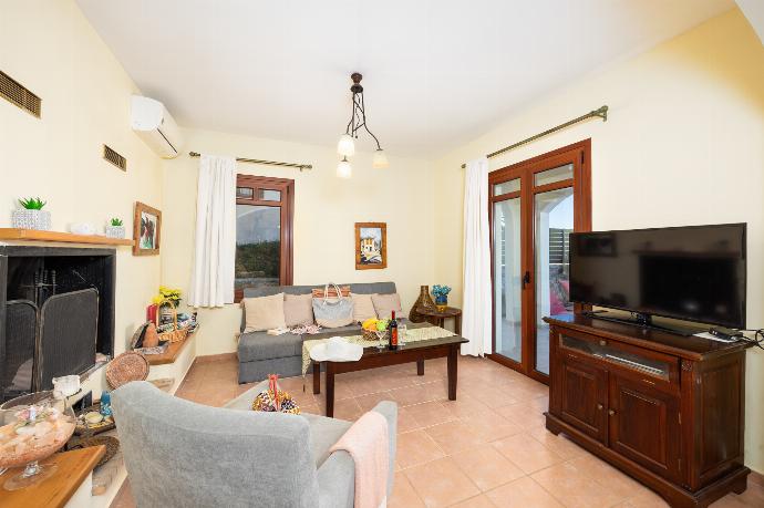 Living room with sofa, ornamental fireplace, A/C, WiFi internet, and satellite TV . - Odysseus Villa . (Photo Gallery) }}
