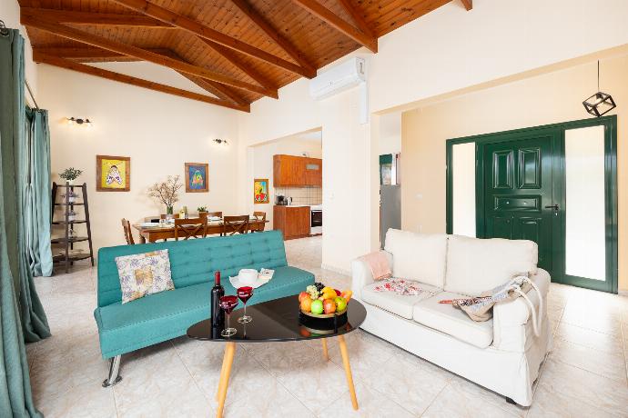 Open-plan living room with sofas, dining area, kitchen, ornamental fireplace, A/C, WiFi internet, and satellite TV . - Villa Phoebe . (Photo Gallery) }}