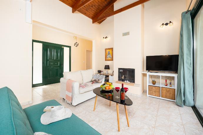 Open-plan living room with sofas, dining area, kitchen, ornamental fireplace, A/C, WiFi internet, and satellite TV . - Villa Phoebe . (Photo Gallery) }}
