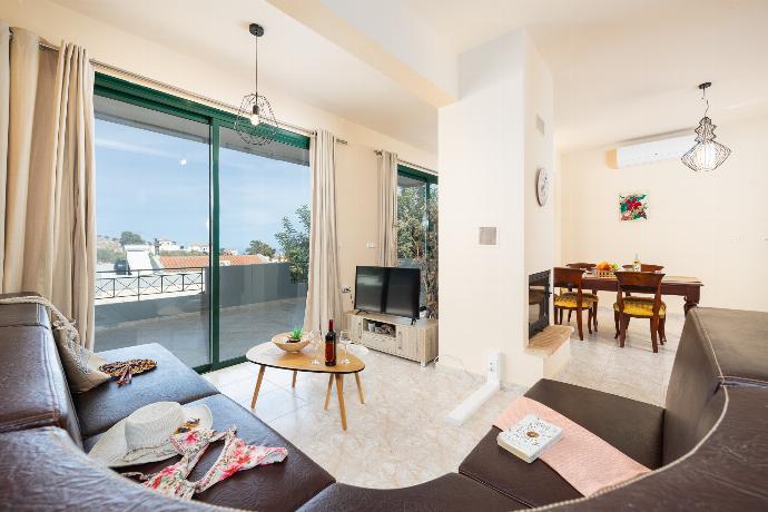 Open-plan living room with sofa, dining area, kitchen, ornamental fireplace, A/C, WiFi internet, and satellite TV . - Villa Phedra . (Photo Gallery) }}