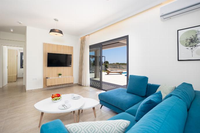 Open-plan living room with sofa, dining area, kitchen, A/C, WiFi internet, and satellite TV . - Villa Pinelopi Tria . (Galleria fotografica) }}