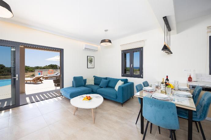 Open-plan living room with sofa, dining area, kitchen, A/C, WiFi internet, and satellite TV . - Villa Pinelopi Tria . (Galleria fotografica) }}