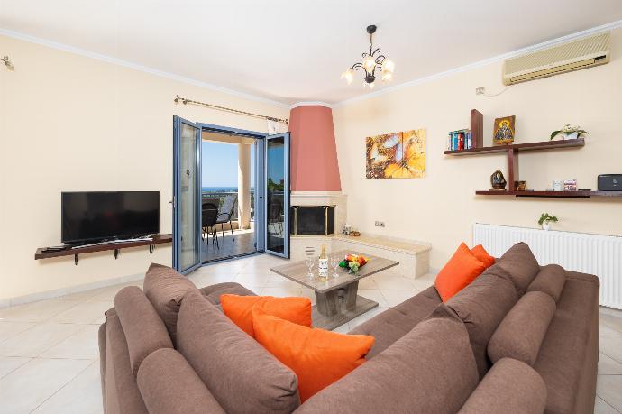 Living room with sofa, dining area, ornamental fireplace, A/C, WiFi internet, and satellite TV . - Villa Xenia . (Galerie de photos) }}