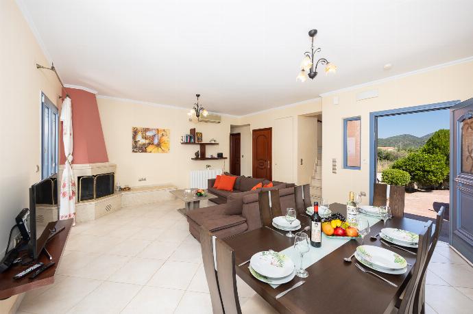 Living room with sofa, dining area, ornamental fireplace, A/C, WiFi internet, and satellite TV . - Villa Xenia . (Galerie de photos) }}