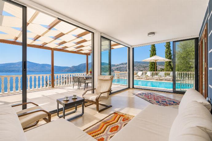 Open-plan living room with sofas, dining area, kitchen, A/C, WiFi internet, satellite TV, and sea views . - Villa Kuluhana . (Photo Gallery) }}