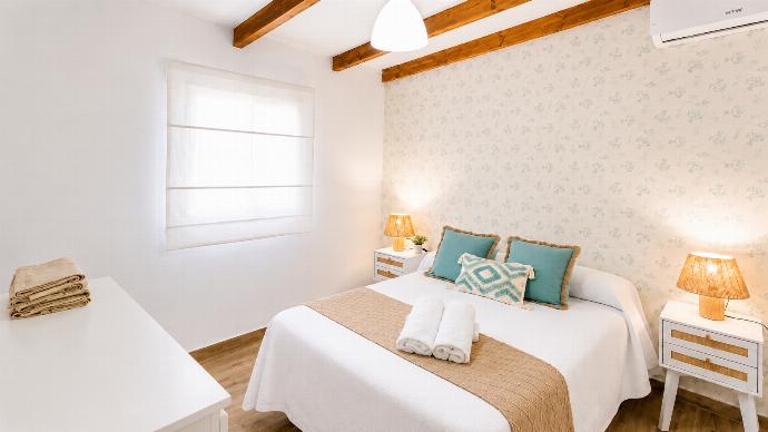 A bright and cozy bedroom with turquoise accents, wooden beams, and soft natural light. . - Villa Casa Romero . (Photo Gallery) }}