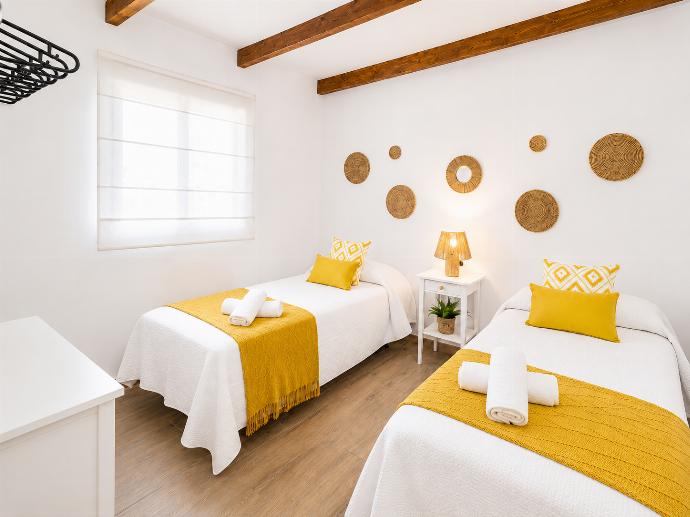 Bright twin bedroom with yellow accents, wooden beams, and warm natural decor. . - Villa Flamenquita . (Galleria fotografica) }}