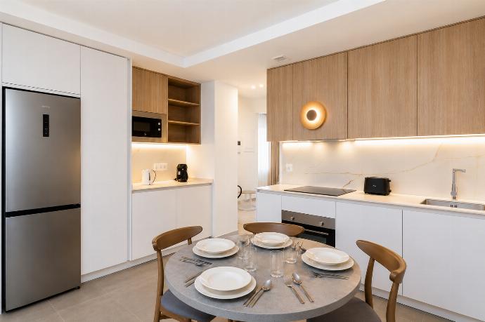 A bright modern open-plan living area with a stylish kitchen, dining space. . - Ereza Residence 1.4 . (Photo Gallery) }}