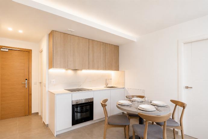 A modern kitchen and dining area with warm wooden cabinetry and elegant neutral decor. . - Ereza Residence 1.4 . (Photo Gallery) }}