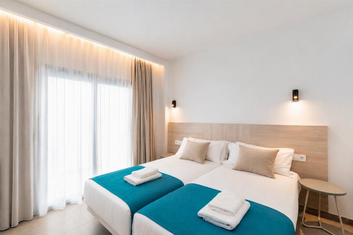 Bright twin bedroom with soft neutral tones, and warm natural light. . - Ereza Residence 1.4 . (Photo Gallery) }}