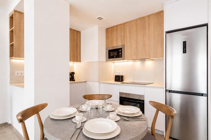 Modern open-plan kitchen and dining area with warm wooden cabinetry and a stylish table setting. . - Ereza Residence 2.1 . (Photo Gallery) }}