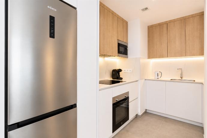 A modern kitchen and dining area with warm wooden cabinetry and elegant neutral decor. . - Ereza Residence 2.2 . (Photo Gallery) }}