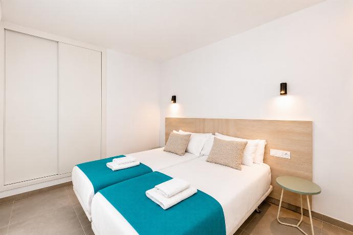 Bright twin bedroom with clean modern decor and a spacious wardrobe. . - Ereza Residence 2.2 . (Photo Gallery) }}