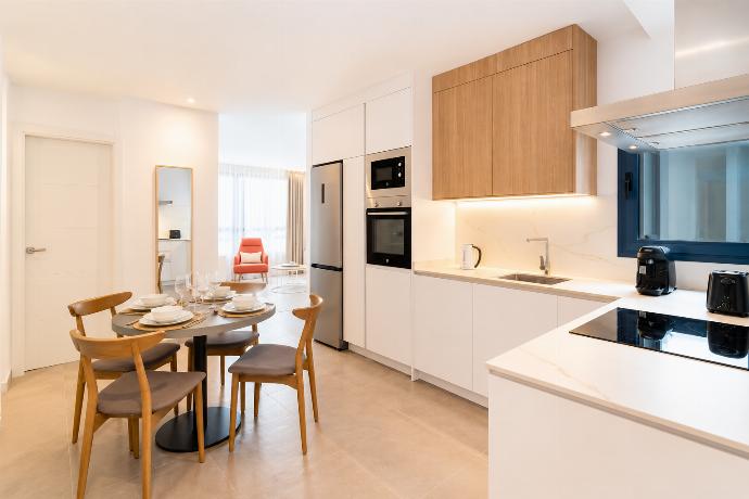 Modern open-plan kitchen and dining area with warm wooden cabinetry and a stylish table setting. . - Ereza Residence 2.3 . (Photo Gallery) }}