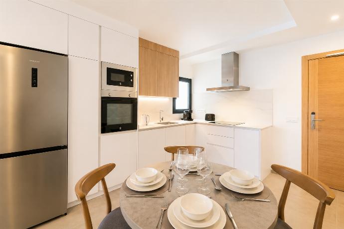 Modern open-plan kitchen and dining area with warm wooden cabinetry and a stylish table setting. . - Ereza Residence 2.3 . (Photo Gallery) }}