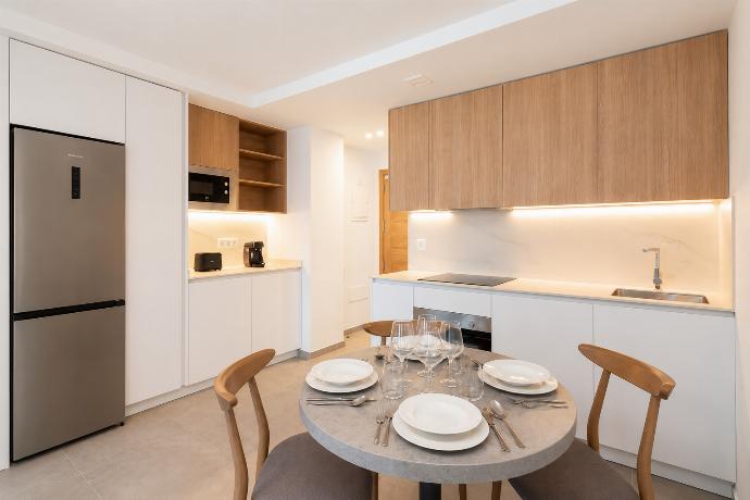 Modern open-plan kitchen and dining area with warm wooden cabinetry and a stylish table setting. . - Ereza Residence 2.4 . (Photo Gallery) }}