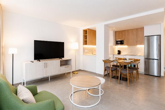 A modern kitchen and dining area with warm wooden cabinetry and elegant neutral decor. . - Ereza Residence 3.1 . (Photo Gallery) }}