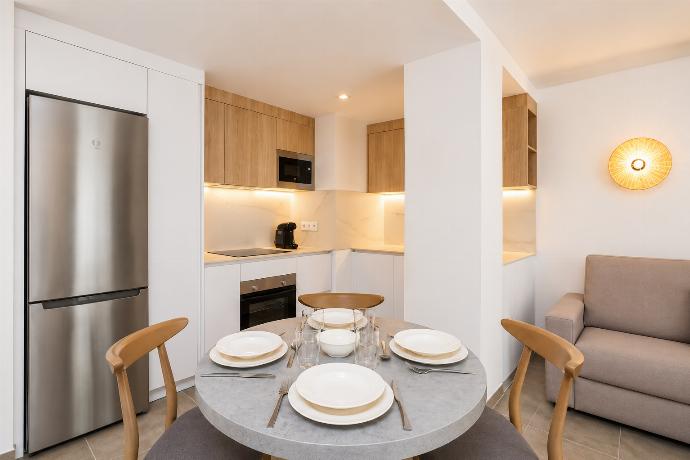 Modern open-plan kitchen and dining area with warm wooden cabinetry and a stylish table setting. . - Ereza Residence 3.2 . (Photo Gallery) }}