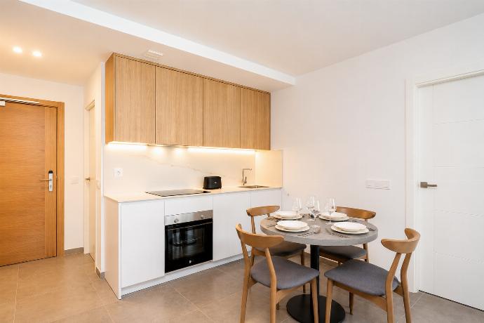 Modern open-plan kitchen and dining area with warm wooden cabinetry and a stylish table setting. . - Ereza Residence 3.4 . (Photo Gallery) }}