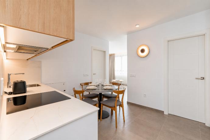 Modern open-plan kitchen and dining area with warm wooden cabinetry and a stylish table setting. . - Ereza Residence 3.4 . (Photo Gallery) }}