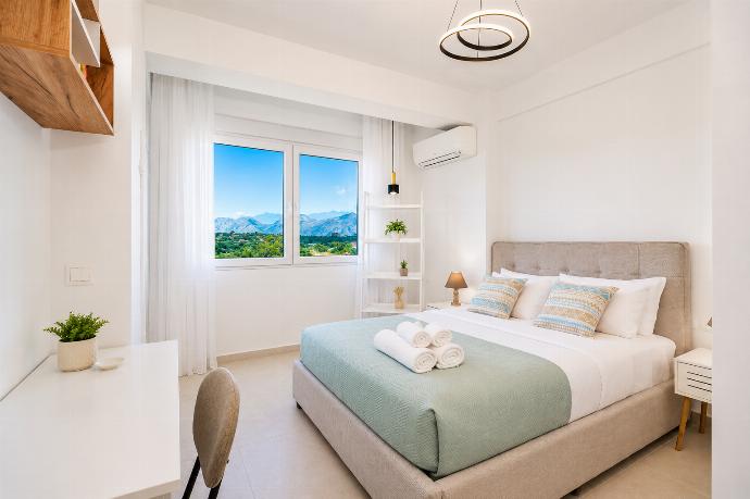 Bright double bedroom with soft green accents, modern decor, and beautiful mountain views. . - Villa Galini . (Galería de imágenes) }}