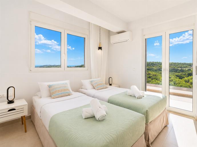 Bright twin bedroom with soft green accents, balcony access, and beautiful countryside views. . - Villa Galini . (Galería de imágenes) }}