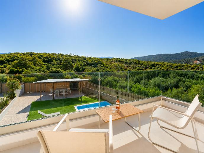 Sunny private balcony with comfortable seating, glass railings, and peaceful forest views. . - Villa Galini . (Galería de imágenes) }}