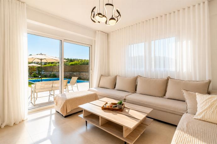 Bright living room with soft neutral decor, elegant curtains, and direct access to the private pool terrace. . - Villa Galini . (Galería de imágenes) }}