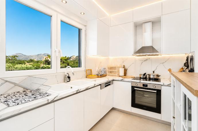 Bright modern kitchen with white cabinetry, marble-style worktops, and beautiful countryside views. . - Villa Galini . (Galería de imágenes) }}