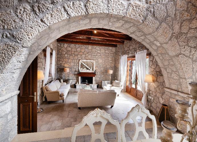 Stone archway opening into a rustic living room with a fireplace. . - Villa Galatia . (Photo Gallery) }}