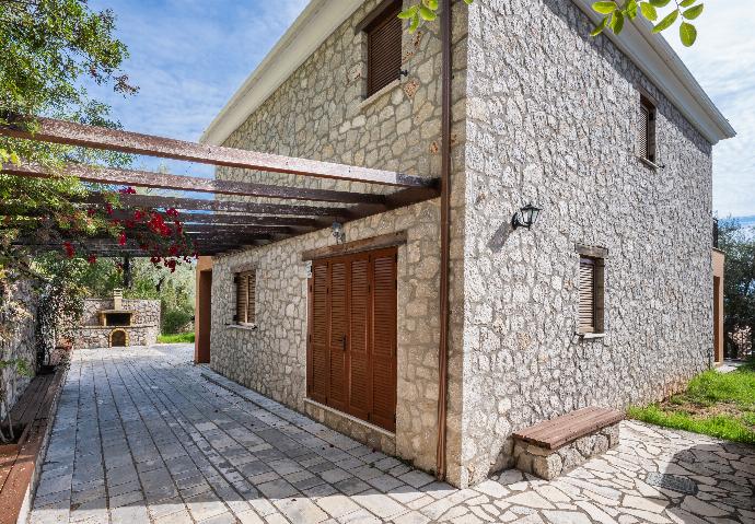 Two-story stone villa with a paved patio, wooden pergola, and shutters. . - Villa Galatia . (Photo Gallery) }}
